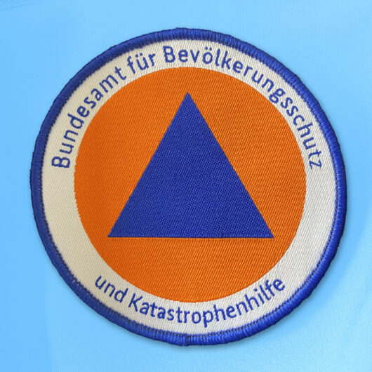 Das internationale Zivilschutzzeichen – ein blaues Dreieck auf orangem Grund – wurde 1973 eingeführt. Es kennzeichnet Zivilschutzorganisationen, ihre Gebäude, Materialien und Schutzbauten