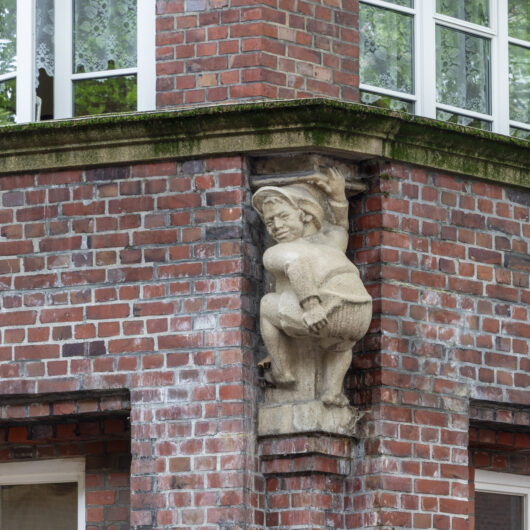 An der Ecke Rademachergang/Breiter Gang zeigt eine Steinfigur eines Jungen seinen Mors neben dem Hummel-Denkmal.