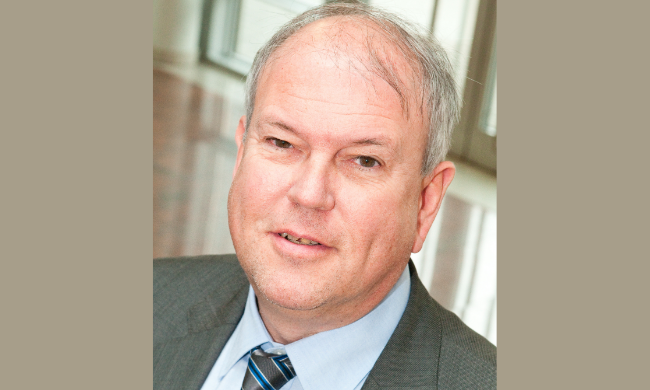 Porträt eines älteren Herren im Anzug mit Krawatte mit grauem Haar.