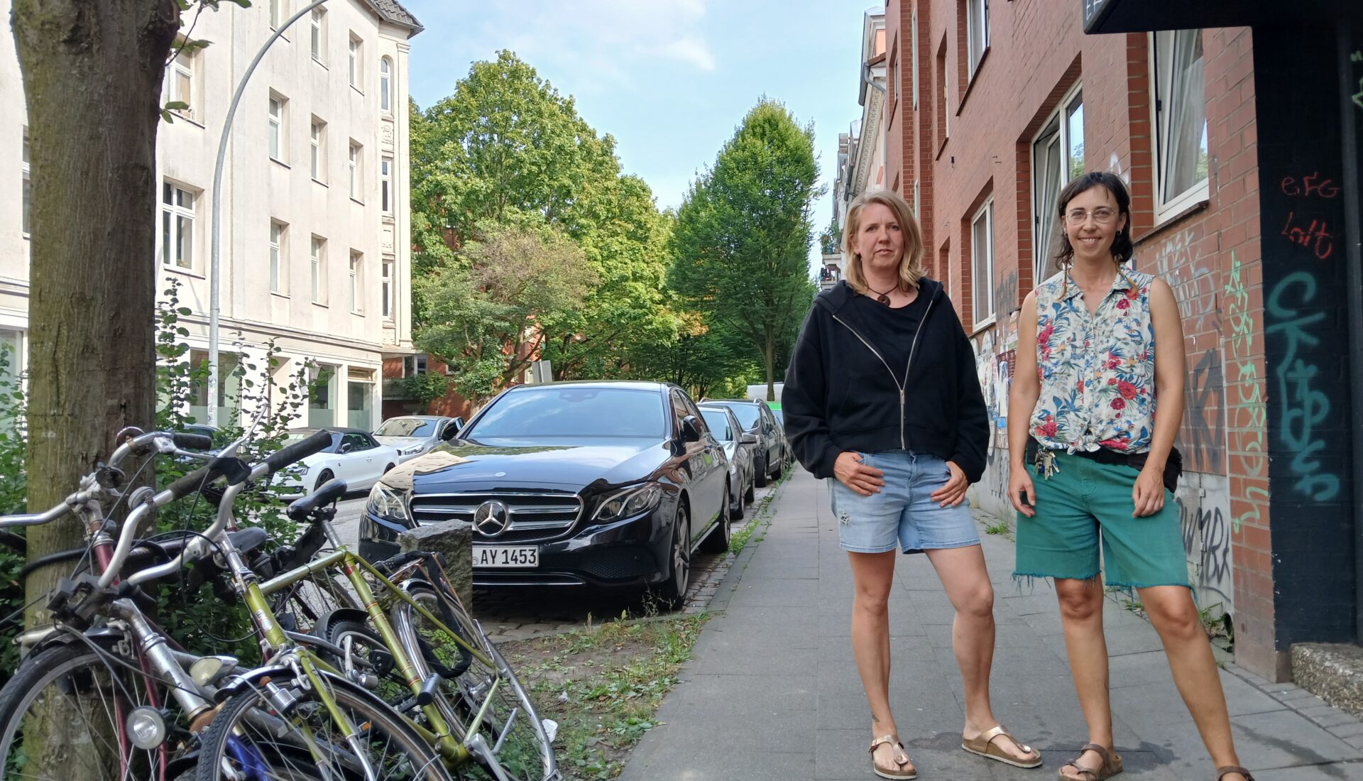 Zwei Frauen stehen auf einem Fußgängerweg.